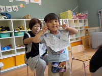 新聞紙で遊ぶ祖母と子ども