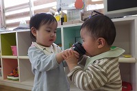 男の子にカップで飲ませる女の子