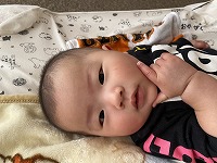 口元に手を当てる赤ちゃん