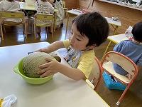 メロンを持とうとする男の子