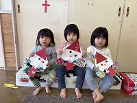 クリスマスツリーの飾りつけをする子ども