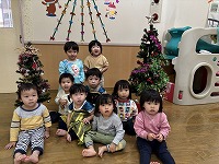 クリスマスツリーの飾りつけをする子ども