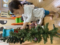 クリスマスツリーの飾りつけをする子ども