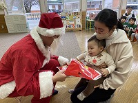 サンタさんからプレゼントをもらう子ども