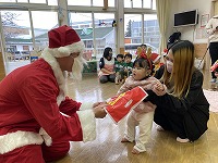 サンタさんからプレゼントをもらう子ども