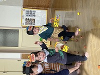 鬼のイラストに豆をまく子どもたち