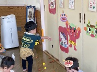 鬼のイラストに豆をまくこどもたち