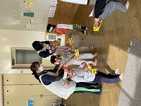 鬼のイラストに豆をまく子どもたち