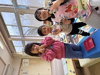 指輪の玩具をいっぱいつけて笑っている子ども