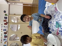 雪がボウルにくっつくのをおもしろがっている子ども