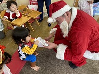 子どもにプレゼントを渡すサンタさん