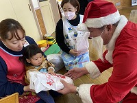 子どもにプレゼントを渡すサンタさん