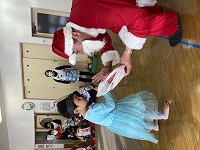 サンタさんからプレゼントをもらう子ども
