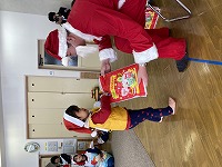 サンタさんからプレゼントをもらう子ども