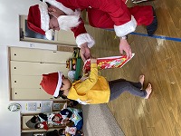サンタさんからプレゼントをもらう子ども