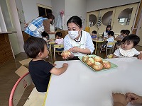 玉ねぎの皮をむいている子どもと先生