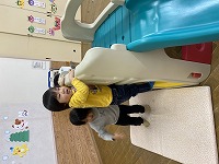 大型すべり台にの登ろうとする子ども