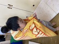 ぬいぐるみをおんぶする子ども