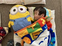 ぬいぐるみと一緒にお昼寝をする子ども
