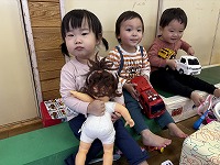 人形と車のおもちゃを持っている子どもたち
