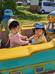 一緒に船の遊具に乗って楽しんでいる子ども達