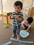 すずらんテープをさいて楽しんでいる子ども