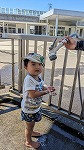 ホースから滴り落ちる水で遊んでいる男の子