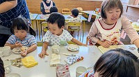 おやつを食べている子どもと先生