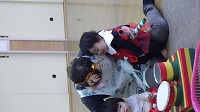 保育士と一緒に太鼓をたたく子ども