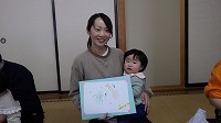 完成した手形アートを持って記念写真