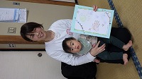 完成した手形アートを持って記念写真