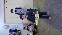 お盆にままごとを乗せて歩く子ども