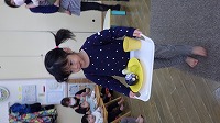 お盆にままごとを乗せて歩く子ども