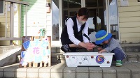 お母さんと男の子が種まきをしている