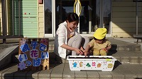 お母さんと女の子が種まきをしている