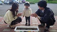 お母さんと女の子とお父さんで種まきをしている