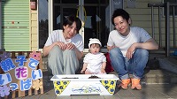 お母さん、女の子、お父さんと種まきをしている