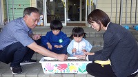 お父さん、お兄さん、女の子、お母さんと種をまいている