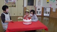 男の子がケーキのろうそくを消している