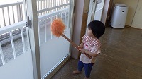 すずらんテープのほうきで窓をきれいにする女の子