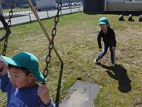ブランコに乗る友達を押す男の子