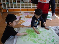 手で絵の具を塗っています