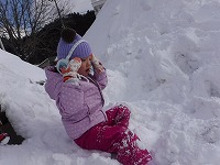 雪の上で一休みしている女の子