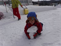雪の塊を運ぼうとしている男の子