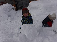 大きな雪の塊を見つけた男の子
