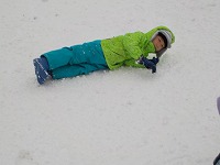 雪に寝そべっている子ども