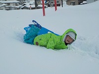 雪にうつぶせに寝るこども