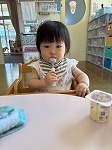 スプーンを使ってダノンを食べる女の子