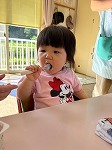 スプーンを使ってダノンを食べる女の子
