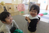 年長児と笑い合う０歳児